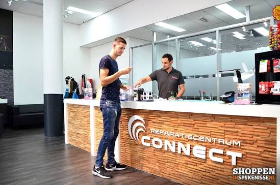 Een klant wordt geholpen aan de balie van Reparatiecentrum Connect