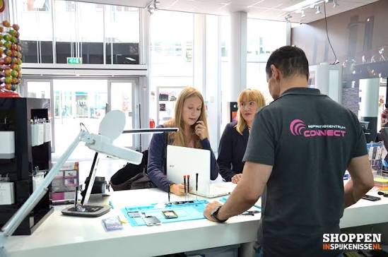 Klanten worden geholpen aan de balie van Reparatiecentrum Connect